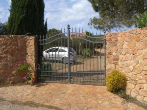 um portão de ferro forjado com um carro estacionado atrás dele em B&B Domus Oriens - monolocale indipendente in villa em Portoscuso