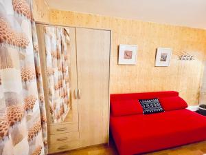 um sofá vermelho num quarto com uma porta em Weisses Rössli em Leukerbad
