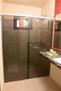 uma cabina de duche em vidro numa casa de banho com 2 lavatórios em Red House Pousada em Flecheiras