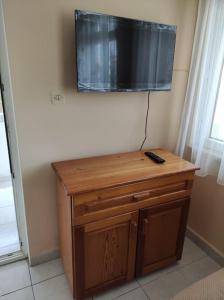 een televisie aan een muur boven een houten tafel bij Private apartment with sea view 5min to Side beach in Side