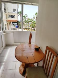 een houten tafel en stoelen in een kamer met een raam bij Private apartment with sea view 5min to Side beach in Side