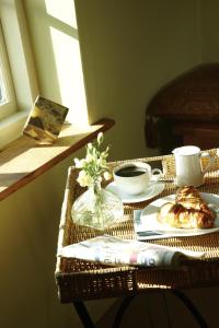 un tavolo in rattan con una tazza di caffè e un piatto di cibo di Hang Your Hat a Winchester