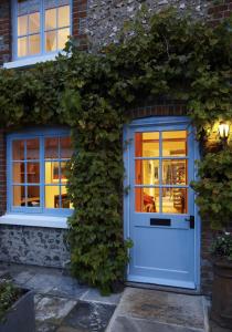 een huis met een witte deur en klimop bij Hang Your Hat in Winchester