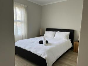 sypialnia z łóżkiem z wypchanym zwierzakiem w obiekcie Happy Home Rondebosch w Kapsztadzie