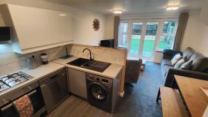 a kitchen with a washer and sink and a living room at Graylingwell! 4/5Bedroom House Chichester Goodwood in Chichester