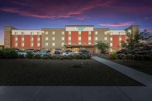 un gran edificio con coches estacionados en un estacionamiento en WoodSpring Suites Phoenix-Deer Valley en Phoenix