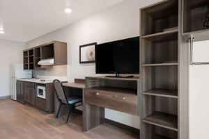 a room with a desk with a computer and a tv at WoodSpring Suites Phoenix-Deer Valley in Phoenix