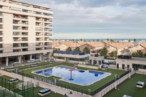 an apartment complex with a large pool in front of a building at Sea view modern flat in Alboraya