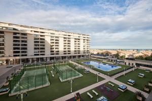 a large building with a tennis court in front of it at Sea view modern flat in Alboraya