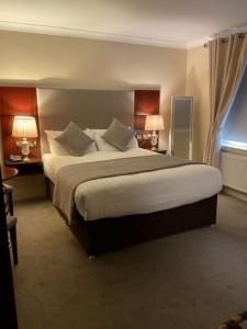 um quarto de hotel com uma cama grande e duas lâmpadas em Shamrock Inn Hotel em Lahinch