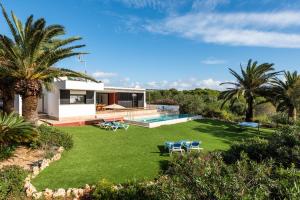 a house with a large yard with a swimming pool at Villa Rosa in Punta Prima