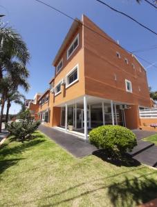 un gran edificio marrón con césped delante en Saint Tropez hotel en Villa Carlos Paz