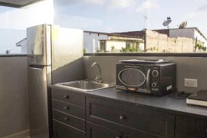 a microwave sitting on a kitchen counter next to a sink at AmazINN Places Private Rooftop and Jacuzzi IX in Panama City