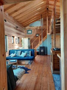 a living room with a blue couch and wooden floors at Casa Puente de Chiloé in Castro
