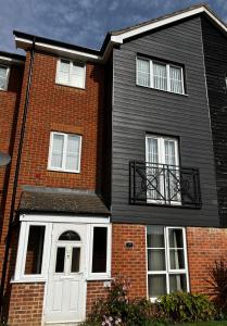 a brick house with a white door and windows at Modern 5 Bedroom House in Willesborough