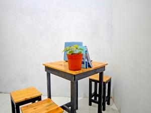 einen Tisch mit einer Topfpflanze darüber in der Unterkunft OYO 91959 La Khansa Homestay Syariah in Sunggal