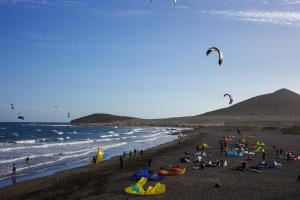 a group of people on a beach flying kites at Medano Nest Hostel in El Médano