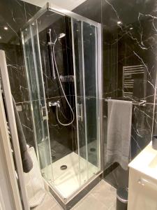 een douche met een glazen deur in de badkamer bij Le Loft Levis in Parijs