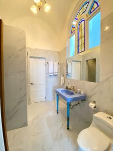 een badkamer met een blauwe wastafel en een toilet bij AmazINN Places Casco Viejo Pool and Rooftop VIII in Panama-Stad
