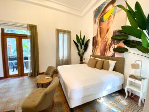 een slaapkamer met een bed, een tafel en een stoel bij AmazINN Places Casco Viejo Pool and Rooftop VIII in Panama-Stad
