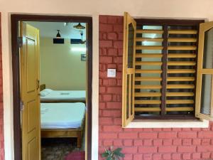 a door to a room with a bed next to a brick wall at Kedige Homestay in Kumta +12 photos