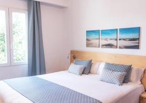 a bedroom with a bed with blue and white pillows at Comitas Tramontana Park in Fornells