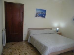 1 dormitorio con 1 cama y puerta de madera en Casa Buenos Aires, en Massa Lubrense