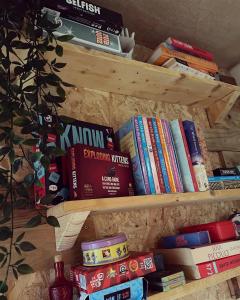 a bunch of books sitting on a wooden shelf at The Cabin Project in Portglenone