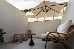 a patio with a table and chairs and an umbrella at ICON Malabar in Málaga