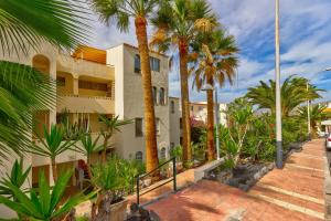 a building with palm trees in front of it at Ocean Loka in Callao Salvaje