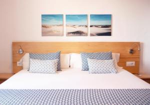 a bedroom with a bed with four pictures on the wall at Comitas Tramontana Park in Fornells
