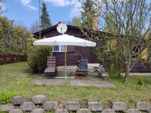 an umbrella and chairs in front of a house at Holiday home in Leanyfalu/Donauknie 35231 in Leányfalu