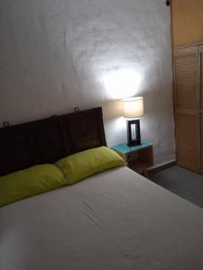 een slaapkamer met een bed met een lamp op een tafel bij Departamento los Mangos in Puerto Vallarta