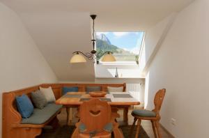 uma sala de jantar com uma mesa e cadeiras e uma janela em Alpengold em Garmisch-Partenkirchen