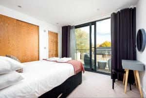 a bedroom with a bed and a large window at Family friendly property in nature reserve The Hangout ML15 in Somerford Keynes +28 photos