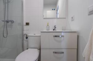 Un baño blanco con inodoro y ducha. en El Mirador de El Puerto, en El Puerto de Santa María 63 fotos más