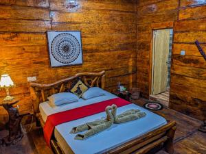 a bedroom with a bed with a stuffed elephant on it at Choona Lodge 'view of sigiriya & pidurangala with sunrise' in Sigiriya