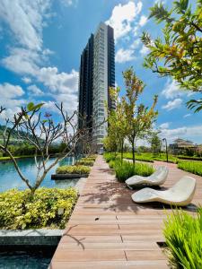 a wooden walkway with two white chairs and a tall building at KL COSY CONDO - NEW Stylish home above KL East Mall in Kuala Lumpur