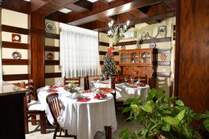 a dining room with two tables and a christmas tree at Il Sole Guesthouse in Porto Torres