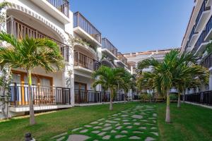 a row of palm trees in front of a building at Hotel Odjo d'água in Santa Maria