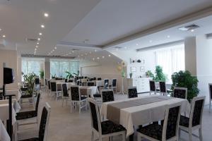 a dining room with white tables and chairs at Hotel Slavey - All Inclusive in Golden Sands