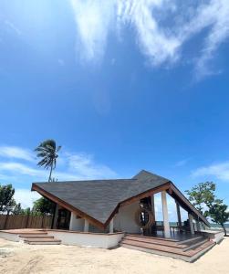 un pequeño edificio en la playa con una palmera en Private beachfront villa en Roxas
