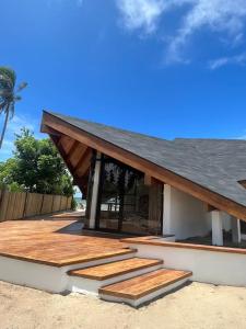 un edificio con terraza de madera con techo negro en Private beachfront villa, en Roxas