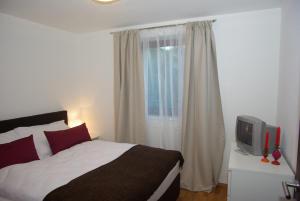 a bedroom with a bed and a tv and a window at Appartement Klausner in Kitzbühel