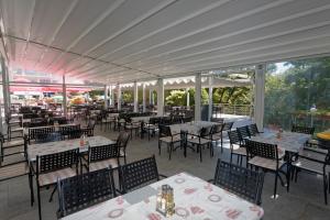 an empty restaurant with tables and chairs and tablesearcher at Hotel Slavey - All Inclusive in Golden Sands