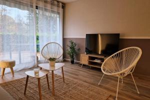 ein Wohnzimmer mit 2 Stühlen und einem Flachbild-TV in der Unterkunft The timelessness of Moirans #EG in Moirans