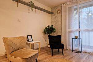 ein Wohnzimmer mit einem Stuhl, einem Tisch und einem Fenster in der Unterkunft The timelessness of Moirans #EG in Moirans