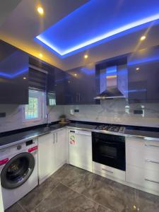 a kitchen with a washing machine and a blue ceiling at Shared Pool Flat Located 3 Min to Beach in Kalkan in Kalkan