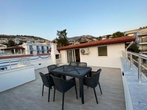 a patio with a table and chairs on a balcony at Shared Pool Flat Located 3 Min to Beach in Kalkan in Kalkan