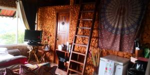 a room with a wooden wall with a ladder at Mandalas Ecolodge in Cerro Azul